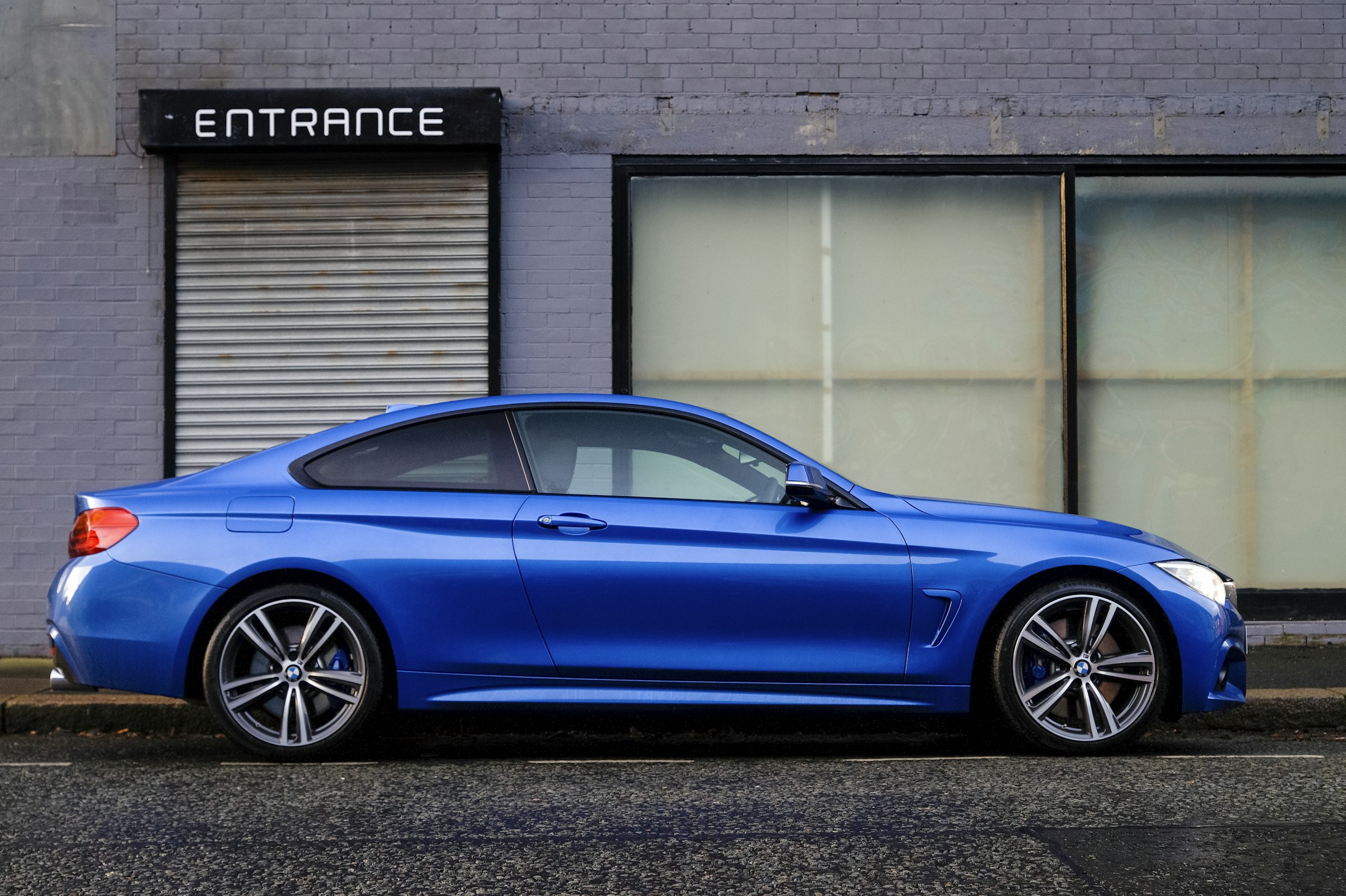 Blue coupe in front of a city entrance
